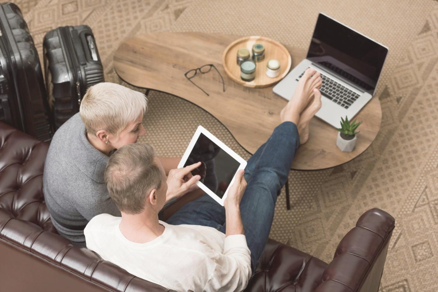 Person reviewing budget reports on tablet with coffee